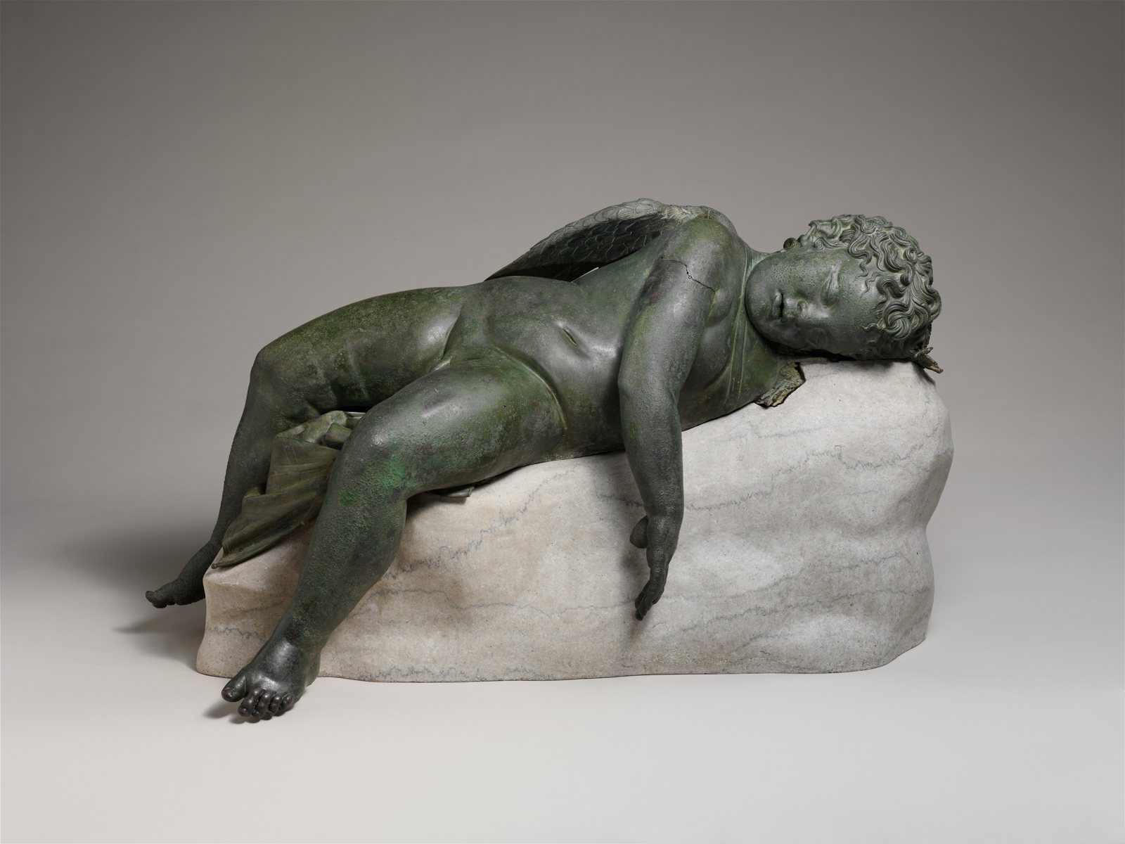 Hellenistic bronze statue of a sleeping winged boy lying on a rock, 3rd to 2nd century BC, of the kind the divers mistook for drowned bodies (this one is in New York, not from the wreck)