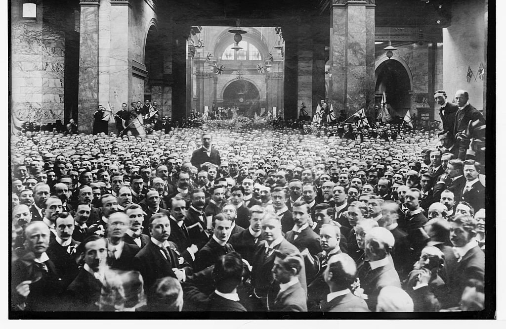 Black-and-white photograph of a packed crowd of men in dark suits on the floor of the London Stock Exchange, between 1910 and 1920