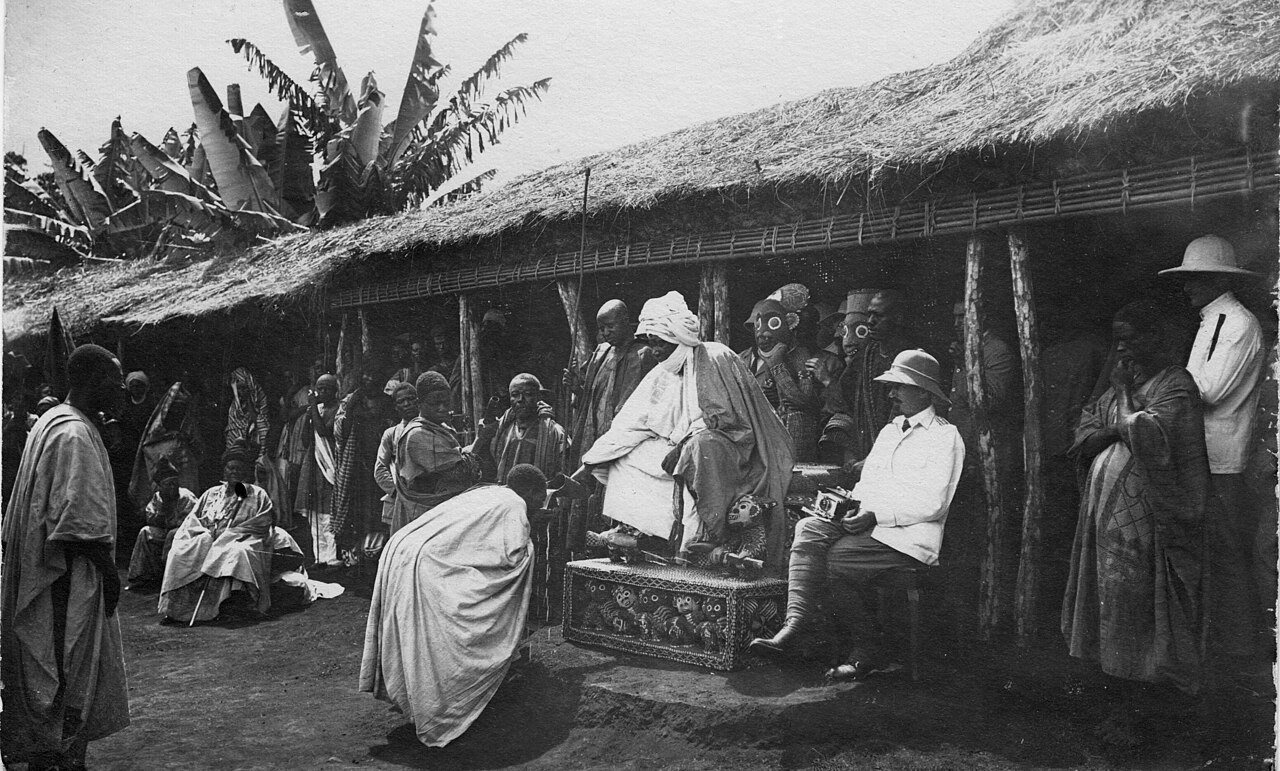 Photograph of King Njoya of Bamum seated on his beaded throne in Foumban, with German colonial officers beside him, early 1900s