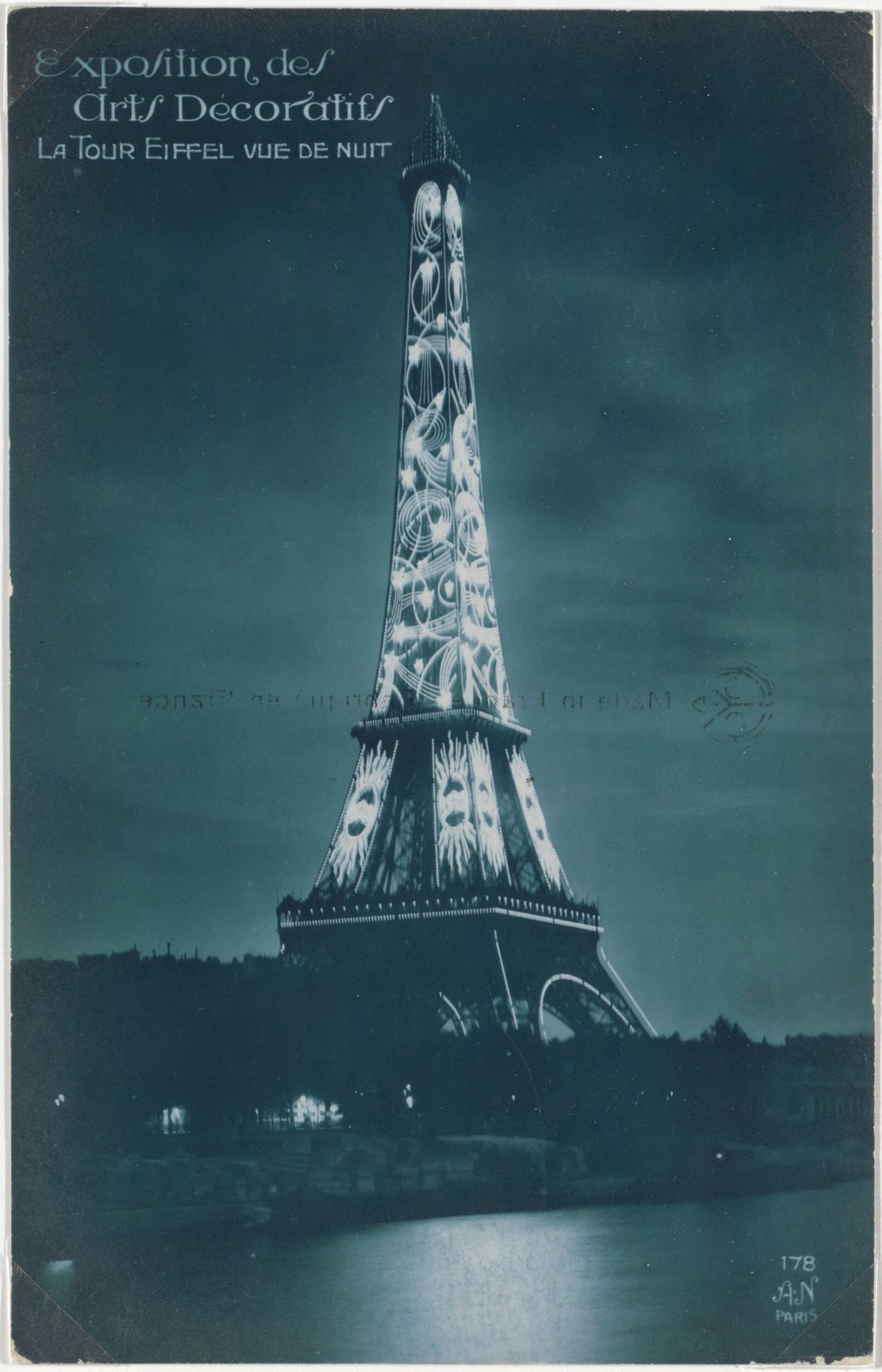 The Eiffel Tower lit up at night during the 1925 Exposition des Arts Décoratifs, on a tinted postcard