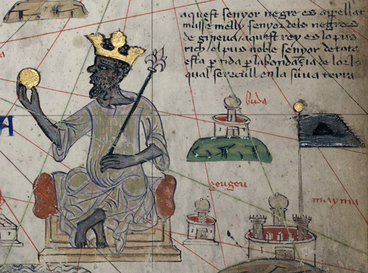 Detail of a medieval map showing a crowned Black king seated on a throne holding a gold coin and a sceptre, with Catalan text beside him