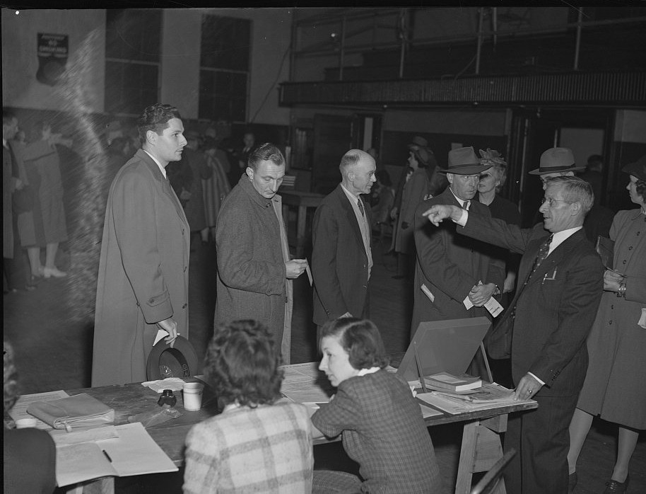 Photograph of voters queuing at a table of poll clerks in a school gymnasium in Olney, Maryland, on election day in November 1942. Marjory Collins, Library of Congress Prints & Photographs Division, no known restrictions