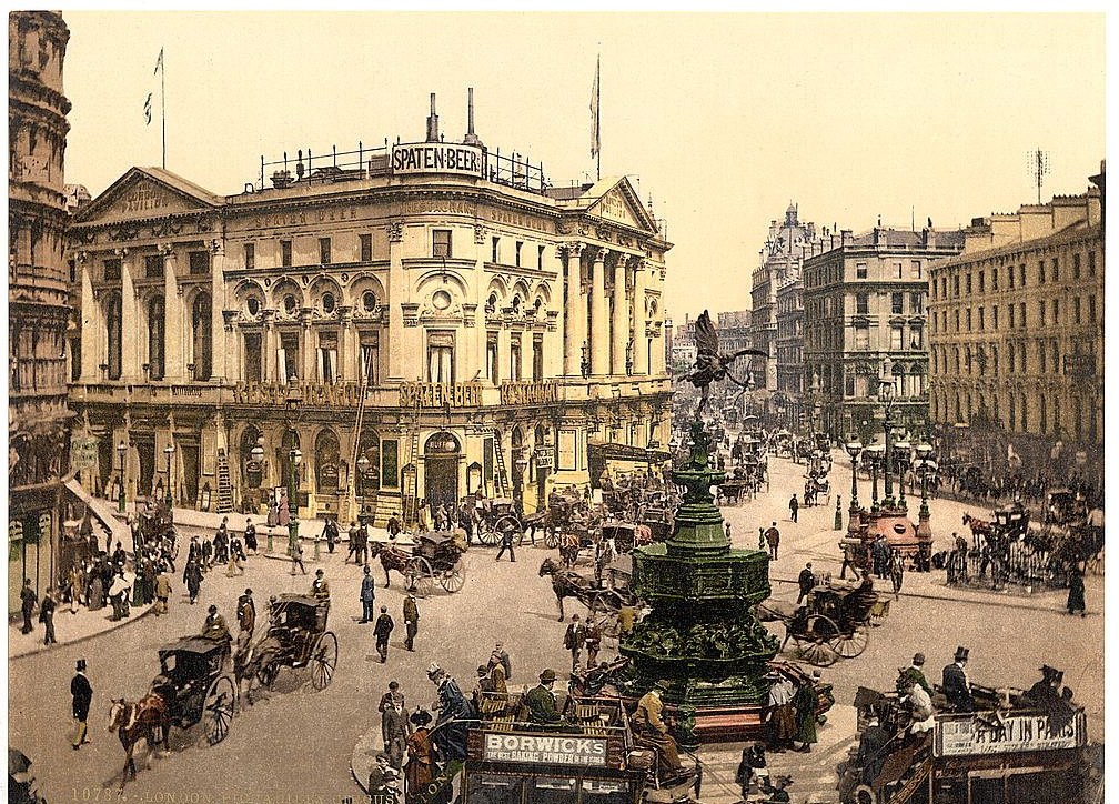Photochrom print of Piccadilly Circus, London, in the 1890s, with horse-drawn cabs and omnibuses keeping to the left around the Shaftesbury fountain